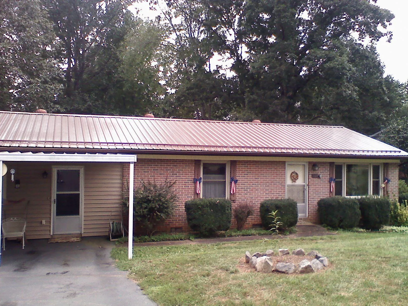 Bronze metal roof and carport on a brick ranch home — Roof Repair work by our crew in Wheeler